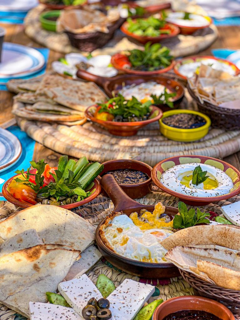 pexels-photo-13555363-13555363 A vibrant Lebanese breakfast spread outdoors with various traditional dishes and fresh ingredients.