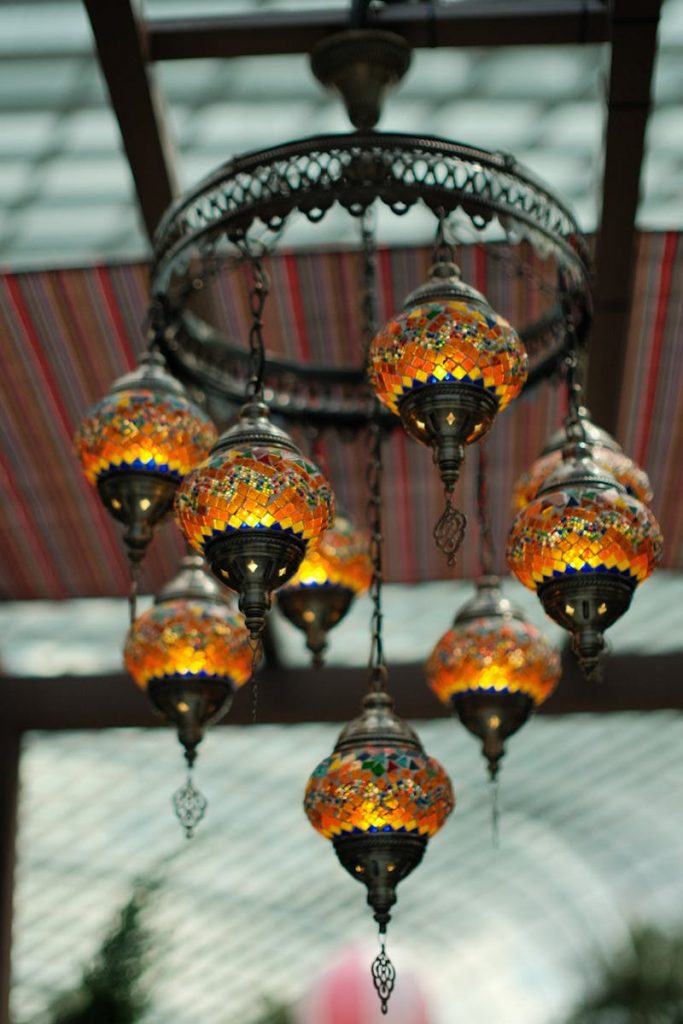 pexels-photo-31581434-31581434 Elegant Moroccan chandelier with colorful glass shades hung in an indoor setting.